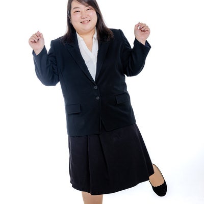 片足立ちで浮かれ気分の女性会社員の写真