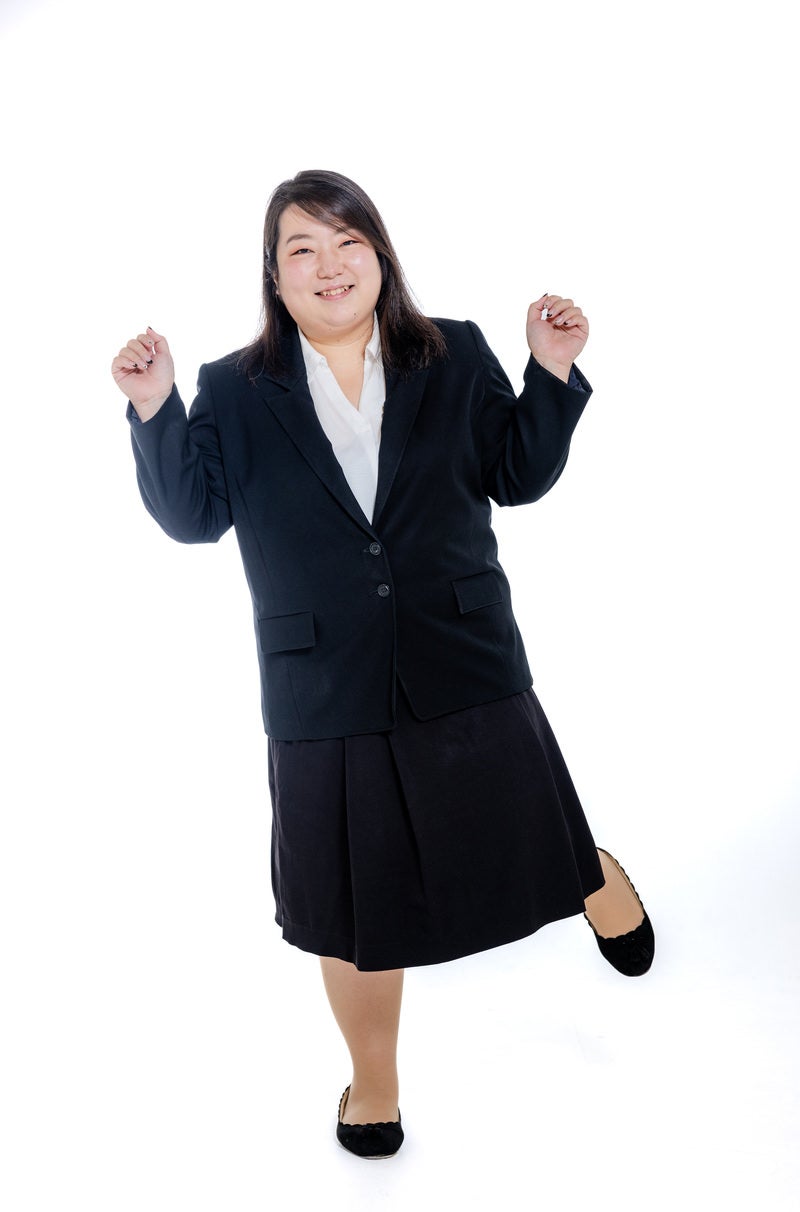 「片足立ちで浮かれ気分の女性会社員」の写真［モデル：KANA］