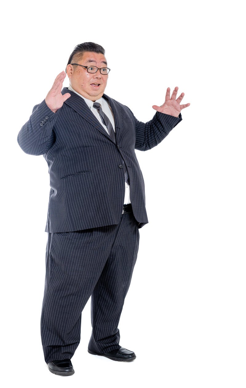 「驚くスーツ姿の肥満男性」の写真［モデル：ダルマ親方］