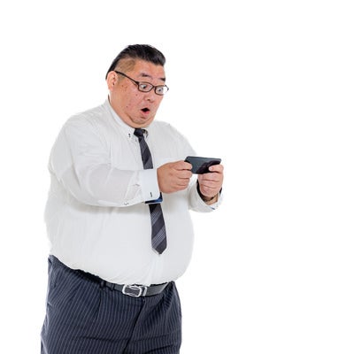 検索結果に驚愕する膨よかな会社員の写真