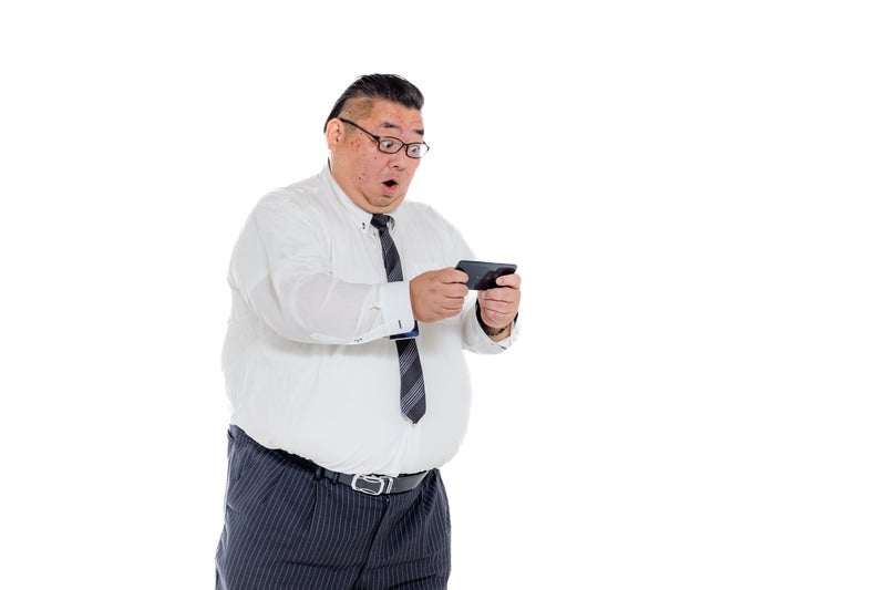 検索結果に驚愕する膨よかな会社員の写真