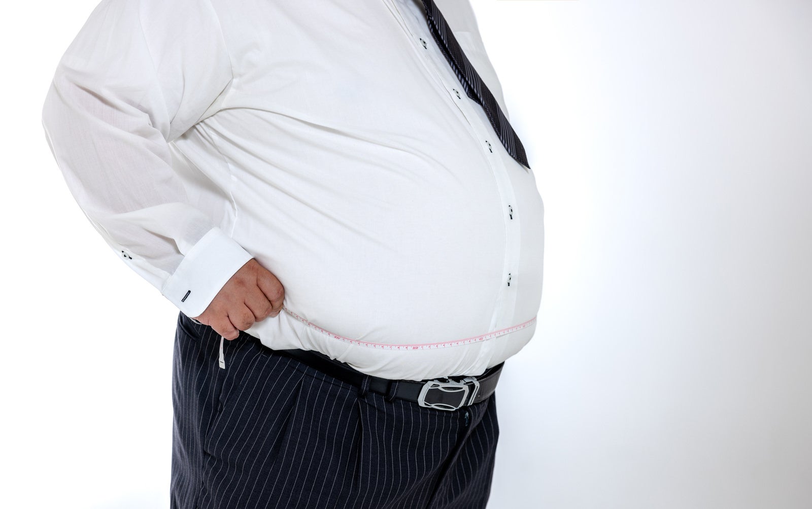 「ウエストを測定する肥満体の会社員」の写真［モデル：ダルマ親方］