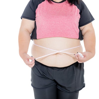 お腹周りを測定中の膨よかな女性の写真