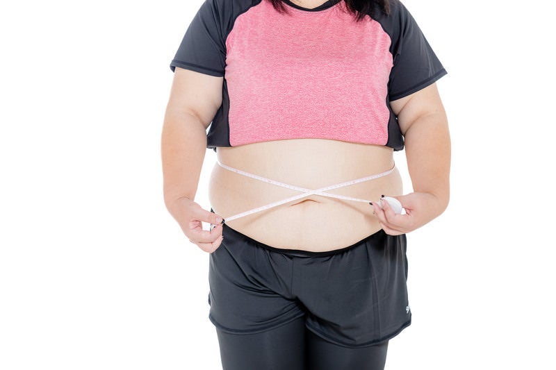 お腹周りを測定中の膨よかな女性の写真