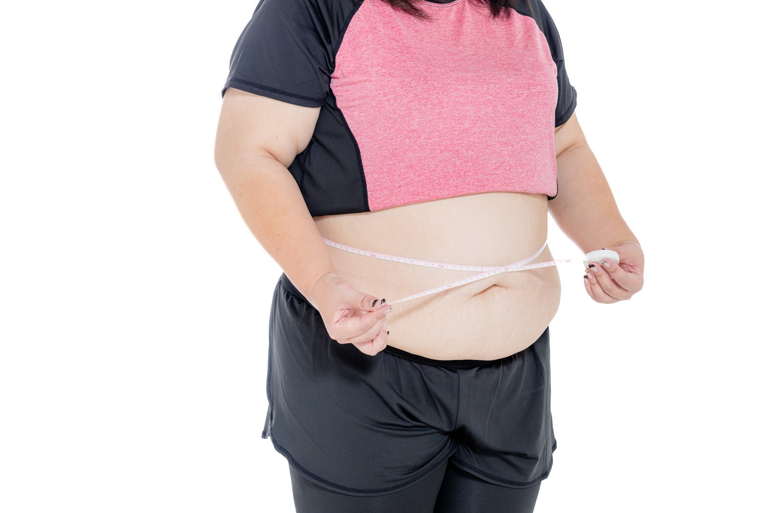 「ぽっちゃりしたお腹周りを測定するぽっちゃりした女性」の写真［モデル：KANA］