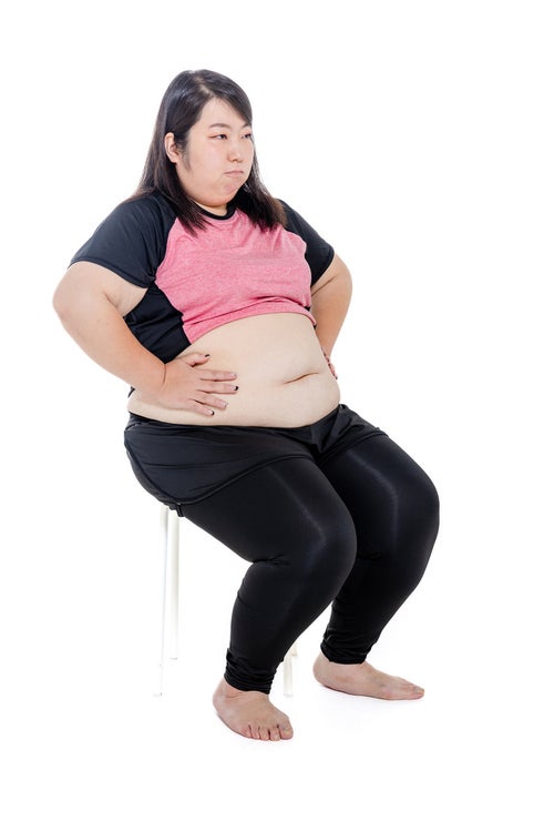 椅子に腰掛けてダイエットに励む膨よかな女性の写真