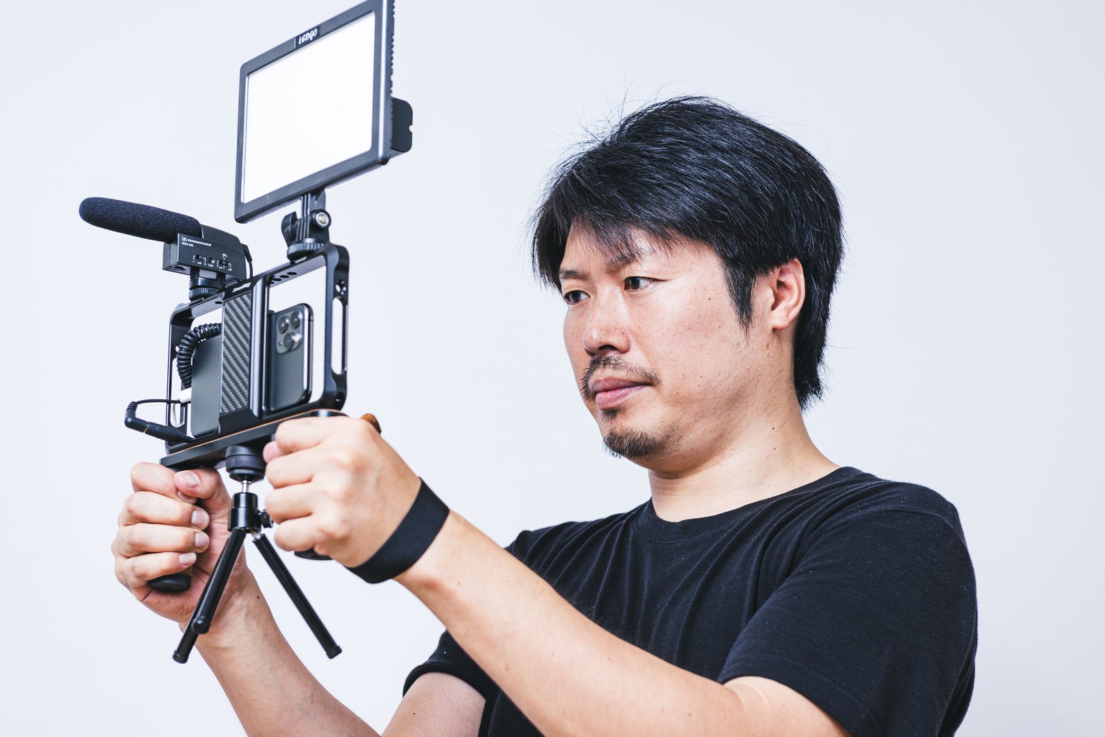 「スマホを使った動画撮影を行うカメラマンの男性」の写真［モデル：瀧野恵太］