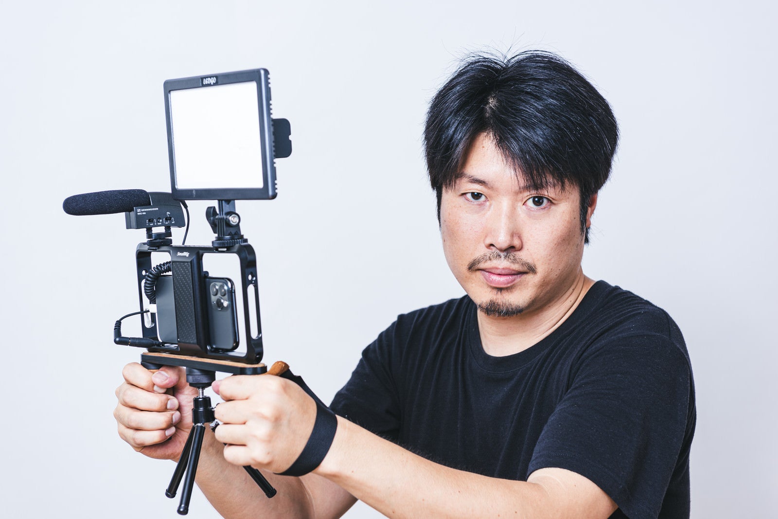 「スマートフォンでムービー撮影をする男性カメラマン」の写真［モデル：瀧野恵太］