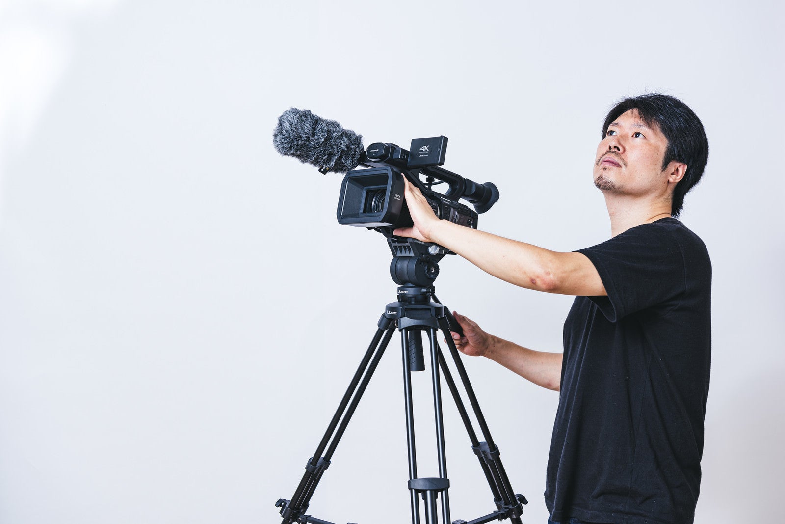 「ビデオカメラを上下に動かすカメラマンの様子」の写真［モデル：瀧野恵太］