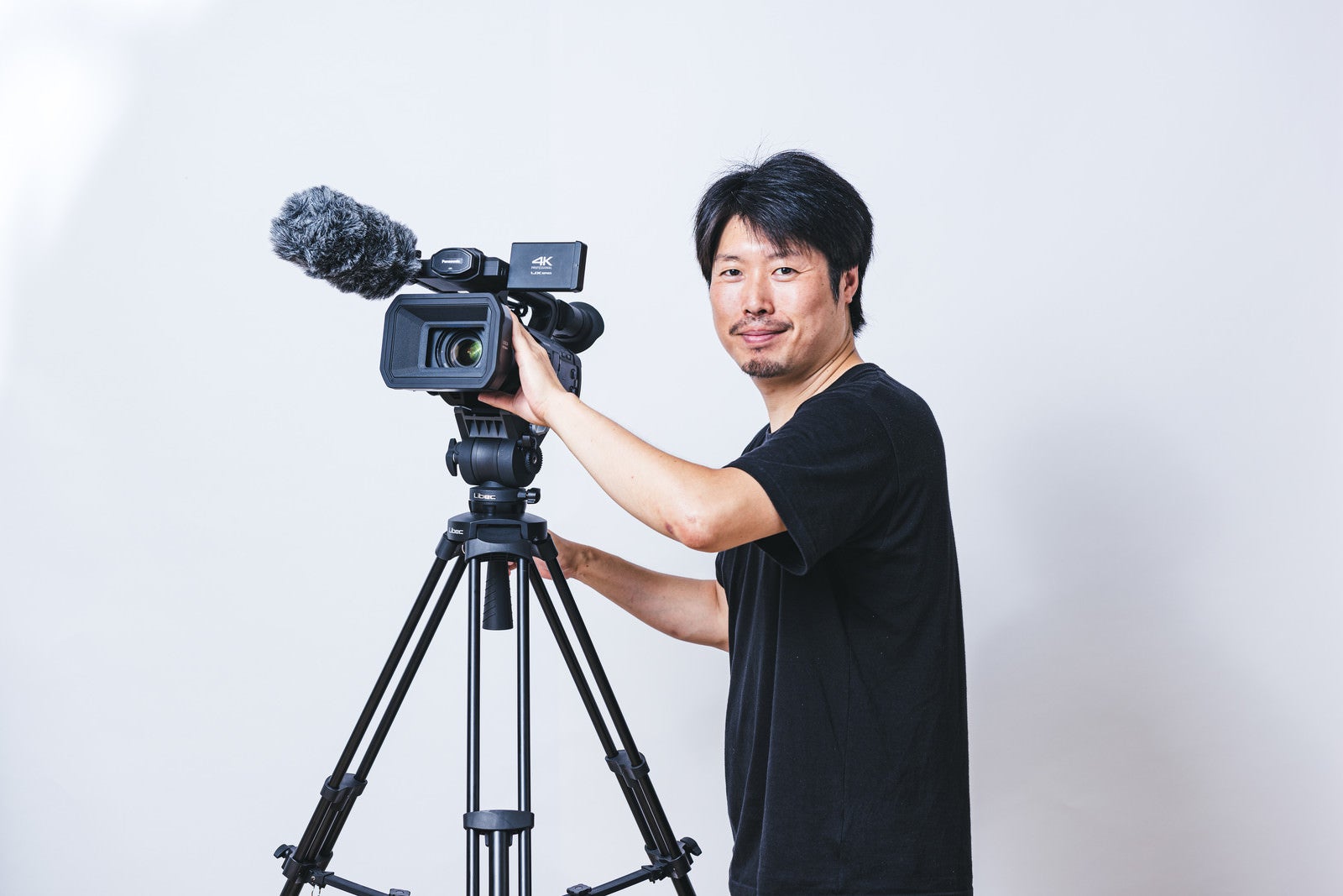 「業務用4Kカムコーダーと撮影者」の写真［モデル：瀧野恵太］