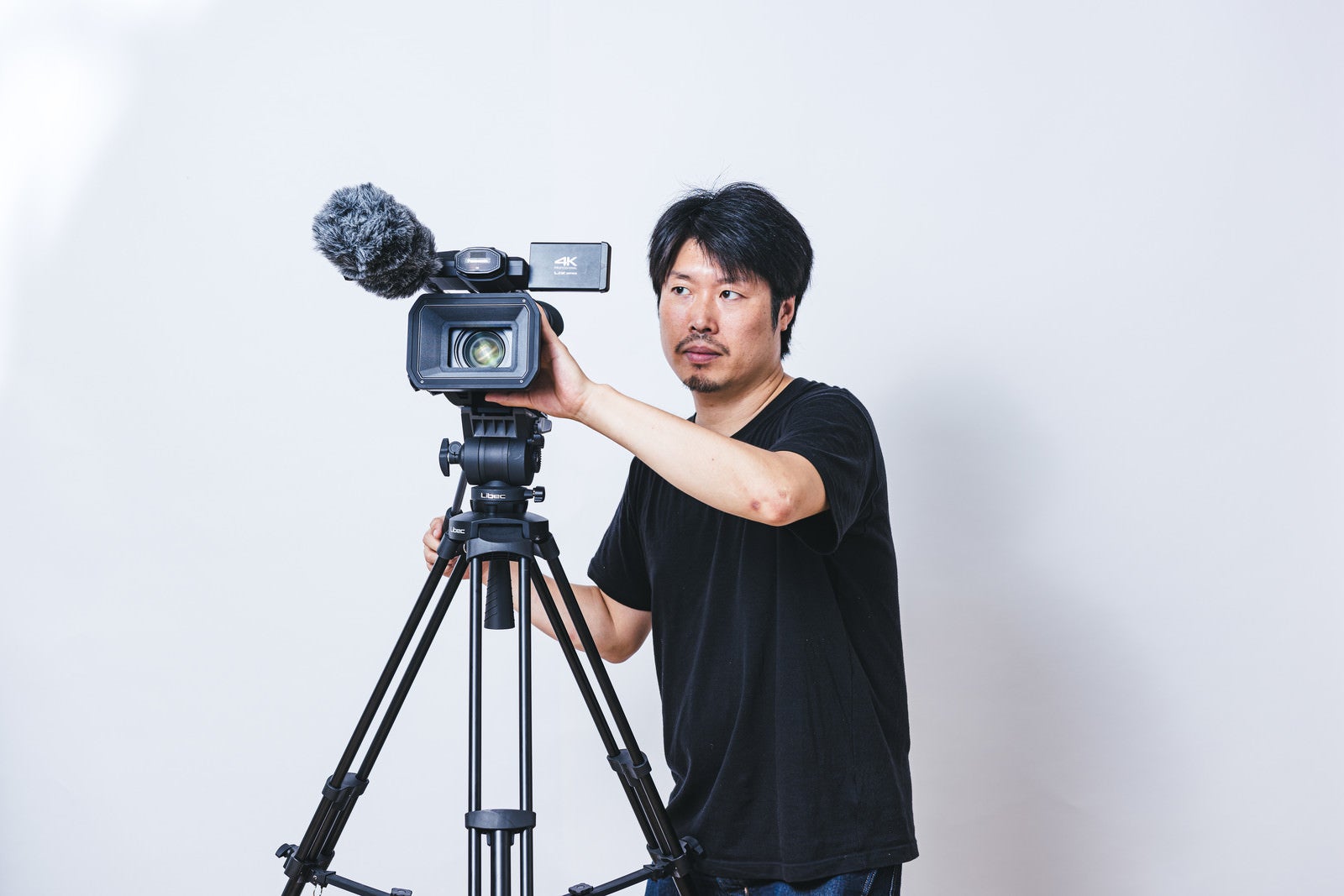 「業務用ビデオカメラを使用するカメラマン」の写真［モデル：瀧野恵太］