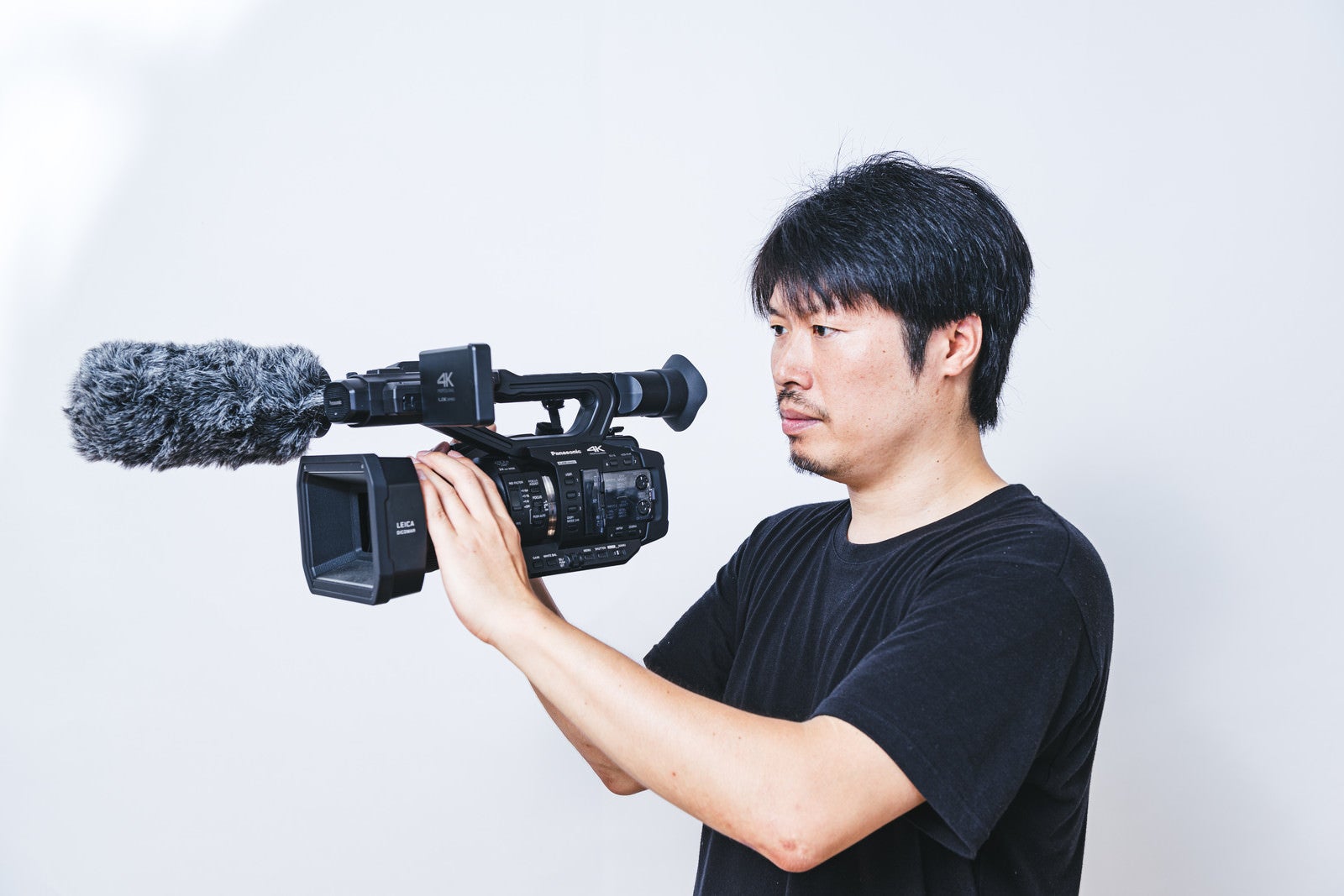 「ハンディで動画撮影する男性カメラマン」の写真［モデル：瀧野恵太］