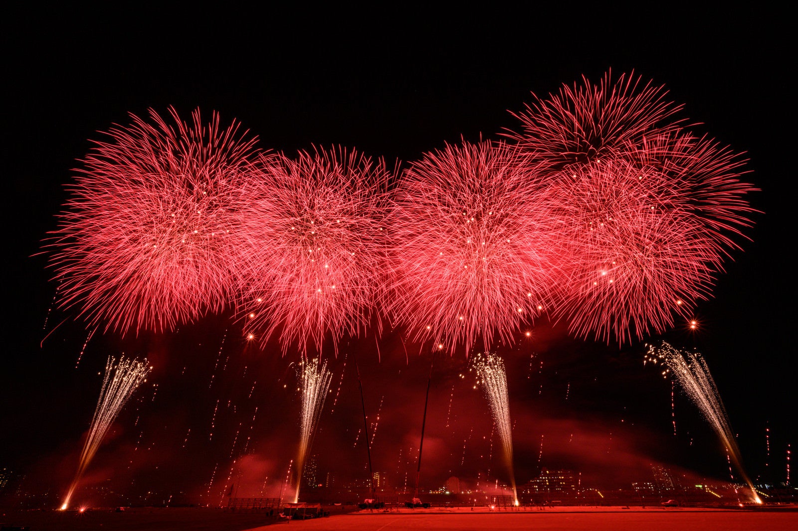 「赤い光が夜空を染める江戸川区花火大会のスターマイン」の写真