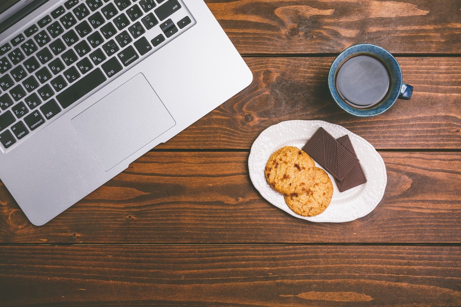 「ノートパソコンで仕事したらコーヒーとお菓子でブレイクタイム」の写真