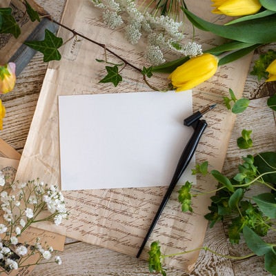 机の上に置かれた花と万年筆の写真