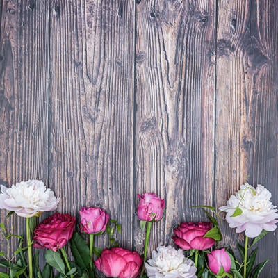 木目の板の上に置いた薔薇と芍薬の写真
