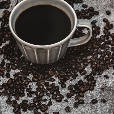 散らばるコーヒ豆と珈琲の写真
