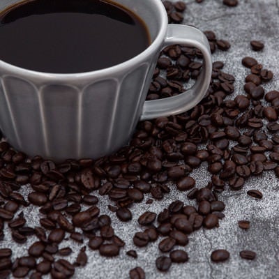 ばら撒かれたコーヒー豆と珈琲の写真