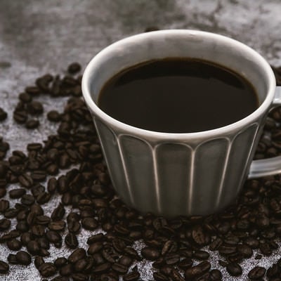 焙煎珈琲豆と注がれたブラックコーヒーの写真