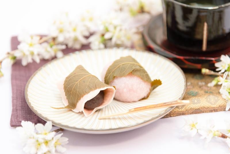 和菓子と桜のある日本の伝統的なおもてなし風景の写真