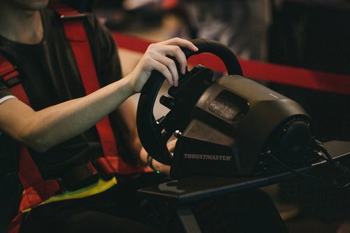 eスポーツのレースゲームでハンドルを持って操作するの写真