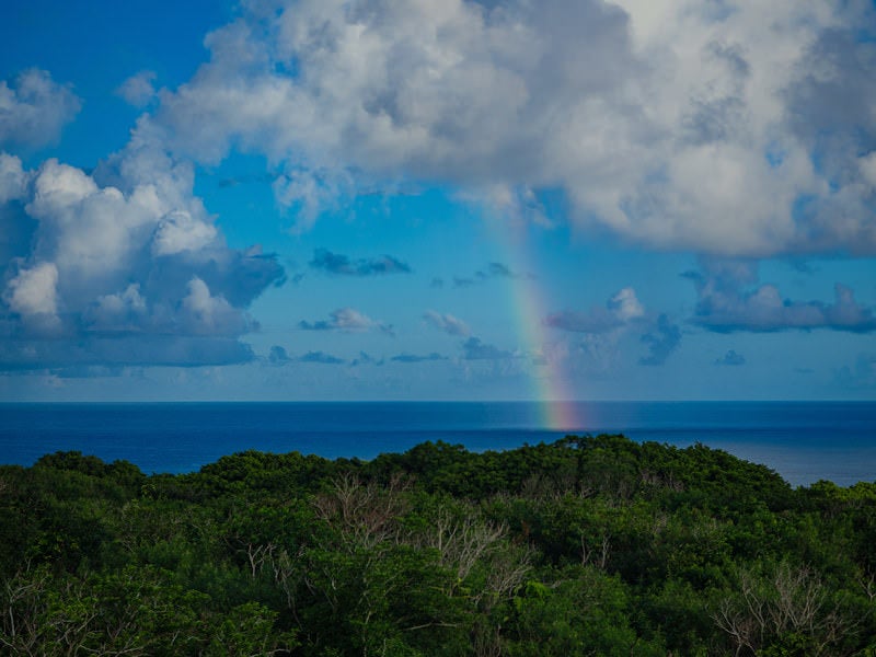 雲と海を繋ぐ虹の写真