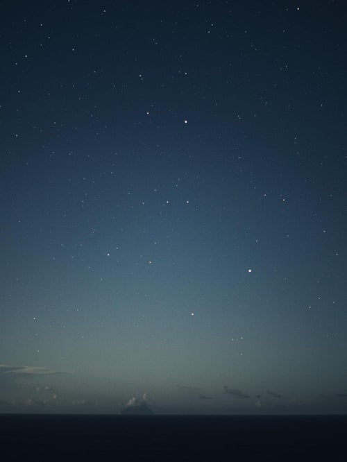 月夜にぼんやりと照らされる南硫黄島の写真