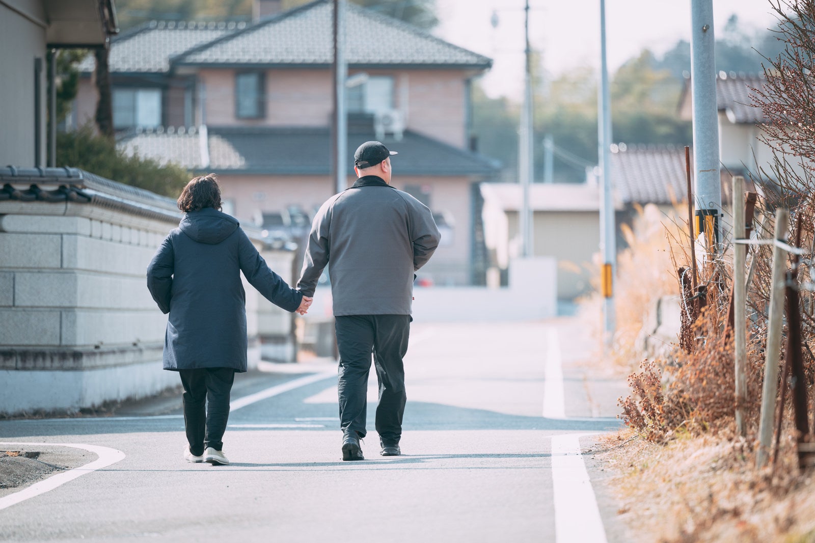「仲良く手を繋いで散歩する夫婦」の写真