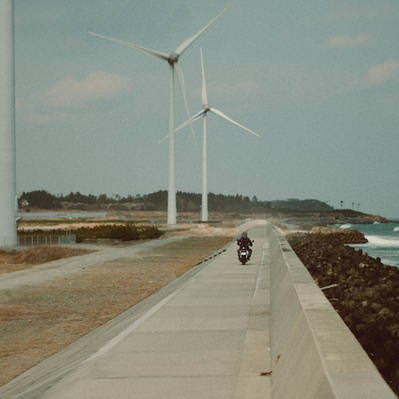 右田海岸の防波堤を颯爽と走るバイカーの写真