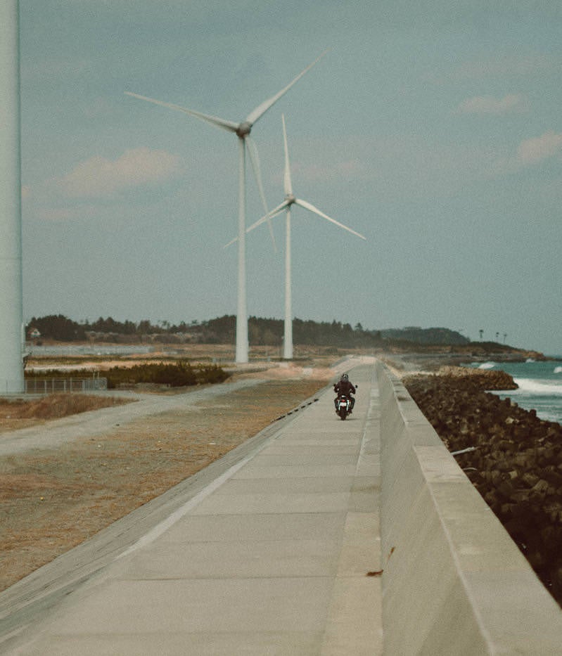 「右田海岸の防波堤を颯爽と走るバイカー」の写真