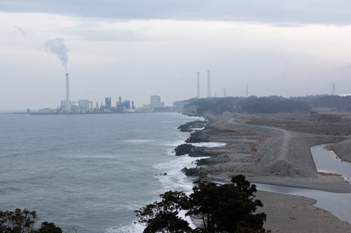 天神岬から見える煙突のある海岸風景の写真