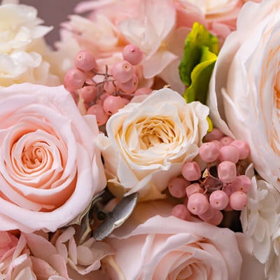 お祝いの気持ちで贈るピンクとクリーム色のバラの花束の写真