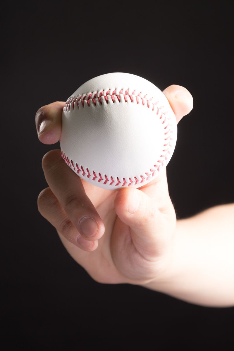「フォークボール（変化球）を握る投手」の写真