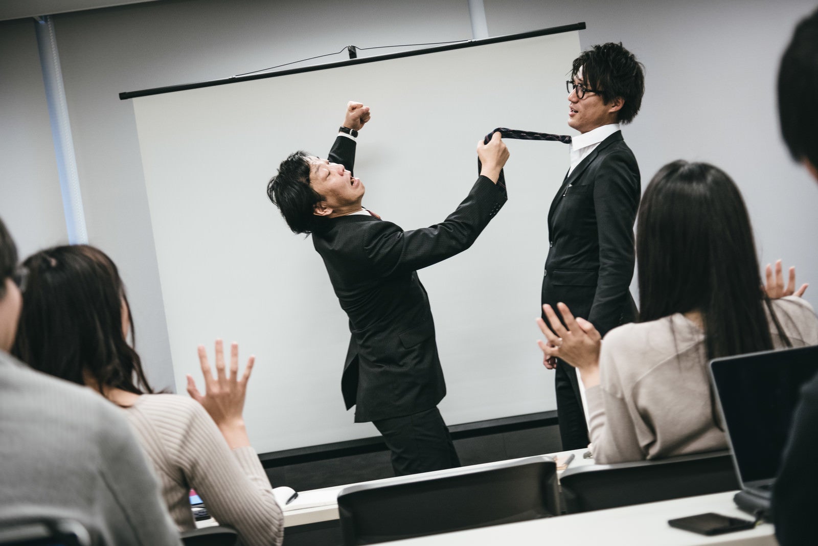 「研修で生意気な新入社員に拳を振り上げる管理職」の写真［モデル：村田裕章 のせさん］