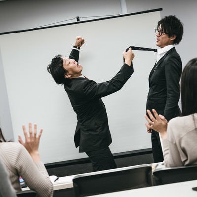 研修で生意気な新入社員に拳を振り上げる管理職の写真