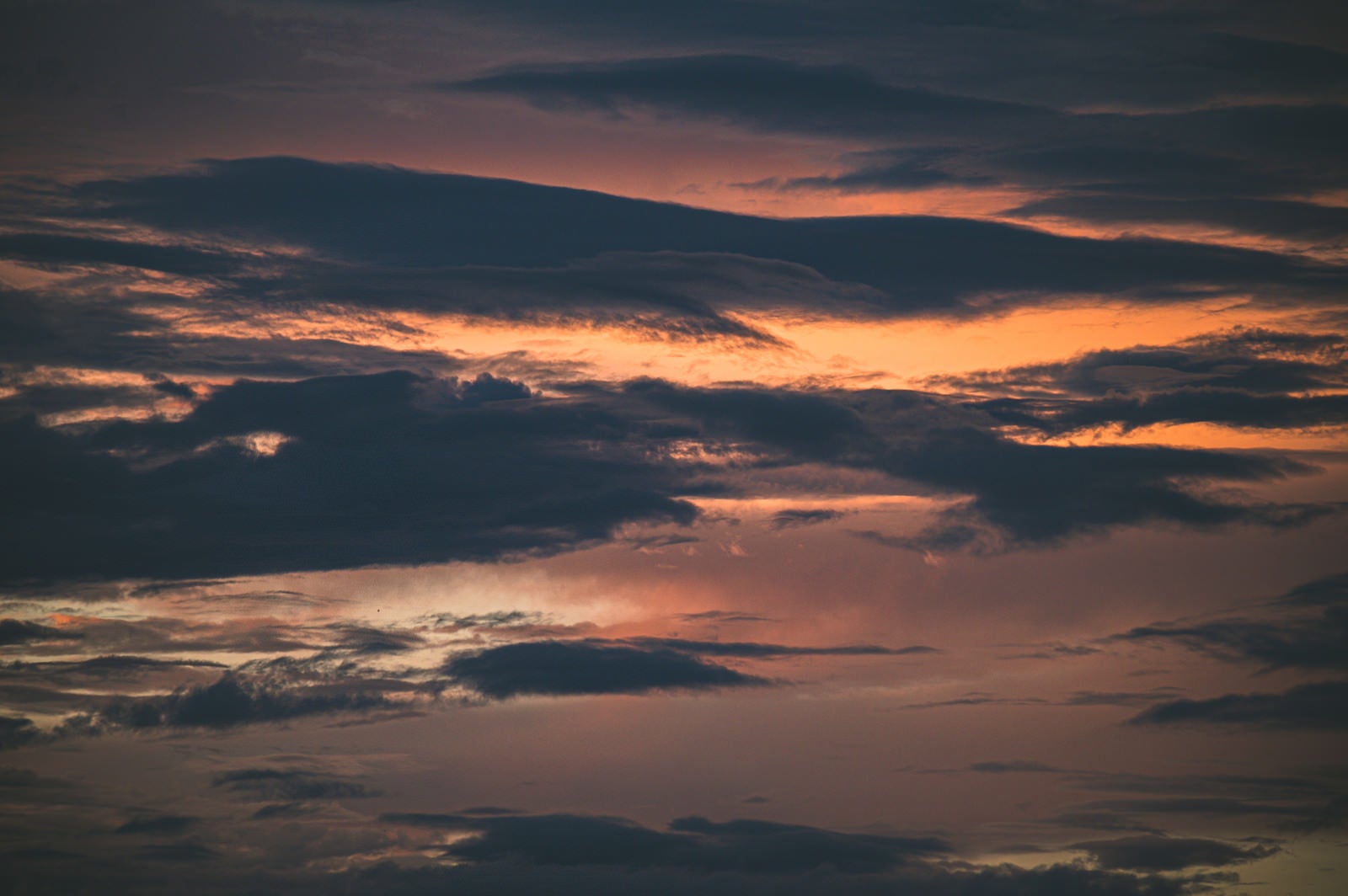 「夕焼けの空を遮る黒い雲」の写真