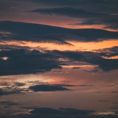 夕焼けの空を遮る黒い雲の写真