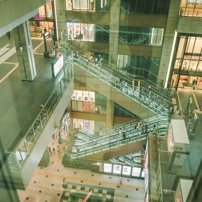 ガラス越しに見た商業施設のエスカレーターの写真