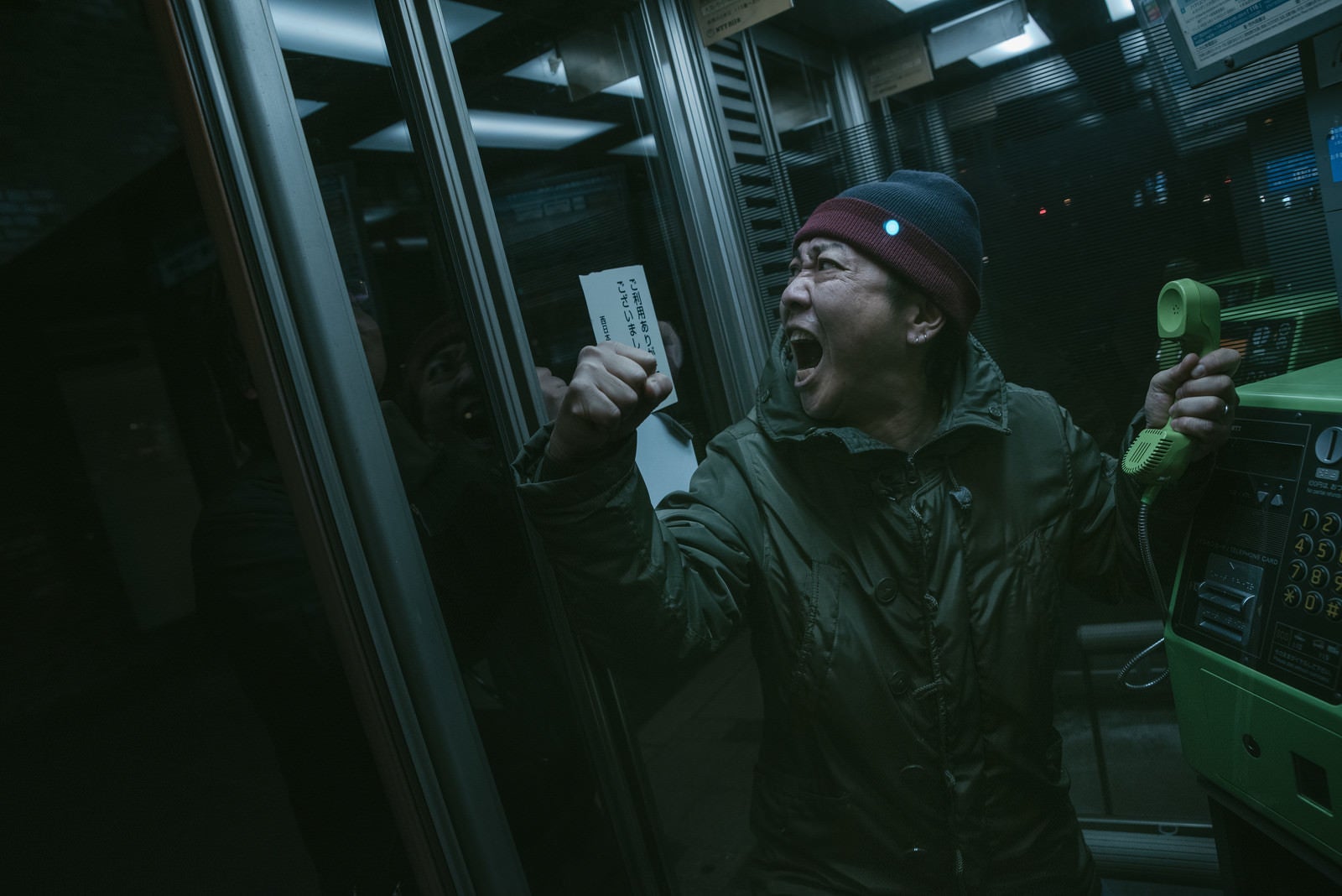 「公衆電話ボックスの中で怒鳴り散らす男性」の写真［モデル：のせさん］