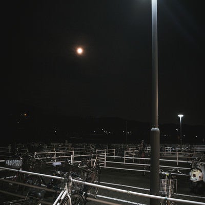 夜の駐輪場と自転車の写真
