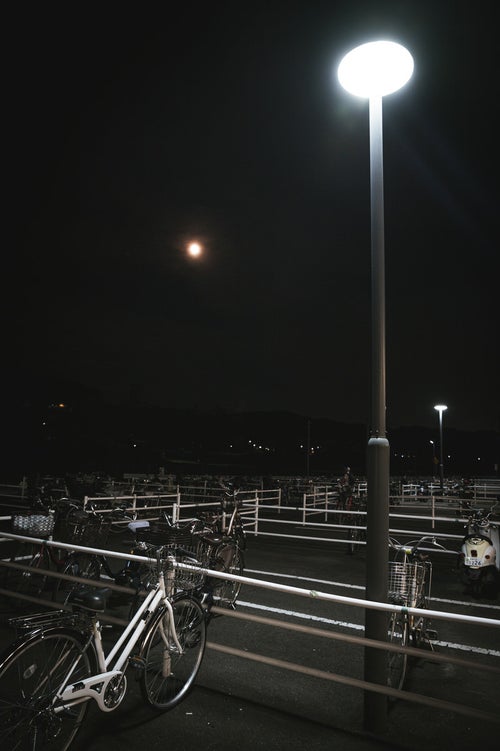 夜の駐輪場と自転車の写真