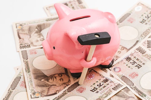 豚の貯金箱と1万円札の写真