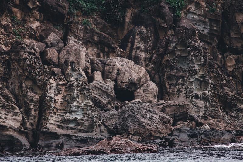 海に削られた褐色の崖の写真