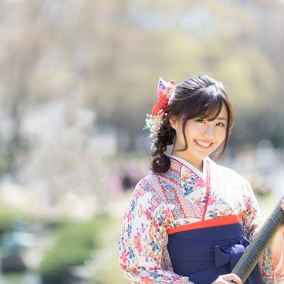 賞状筒を持った袴姿の卒業女子の晴れやかなポートレートの写真