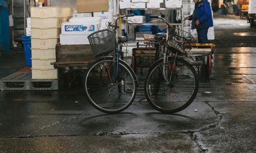 割れたアスファルトと年期の入った自転車（築地市場内）の写真
