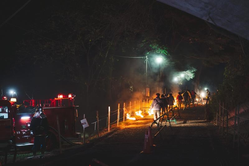 炎を持ち歩く松明あかしの参列者の写真