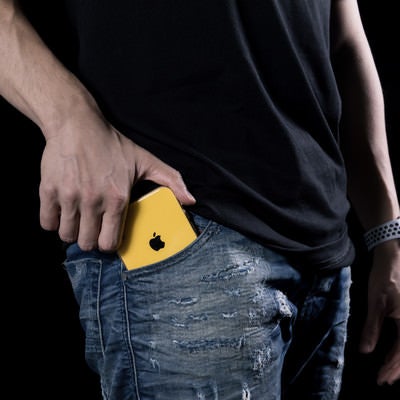さり気無くポケットに入れる黄色のiPhoneXRの写真