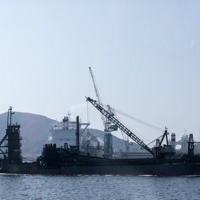 フェリーの後姿と海砂採取船（長崎県）の写真