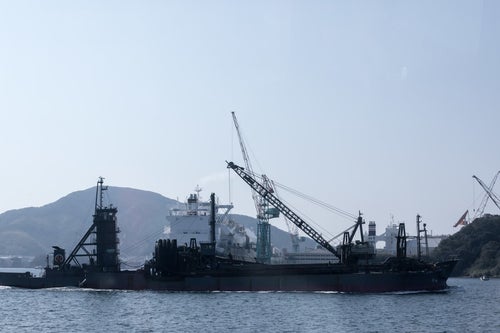 フェリーの後姿と海砂採取船（長崎県）の写真