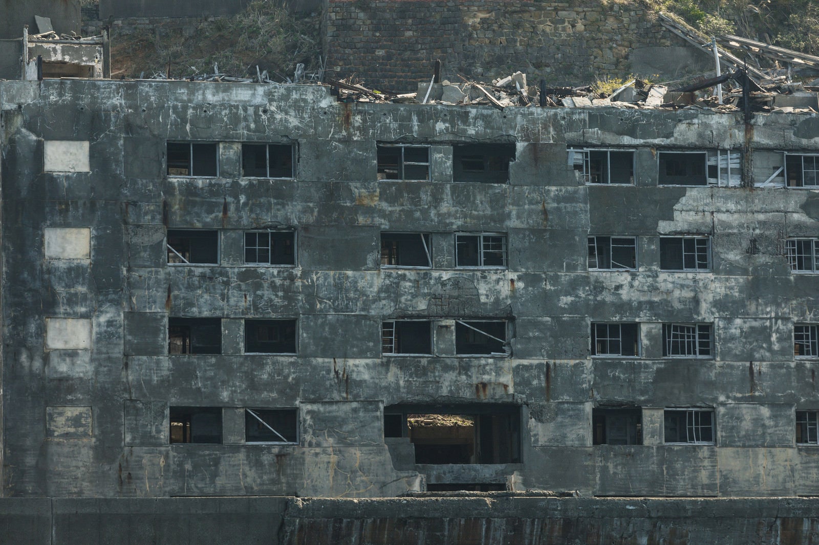 「崩れた窓が不気味に残る31号棟（軍艦島）」の写真